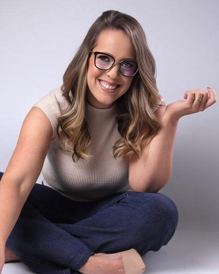 Jane Pinheiro, contadora e planejadora financeira, sorrindo sentada entre post-its coloridos